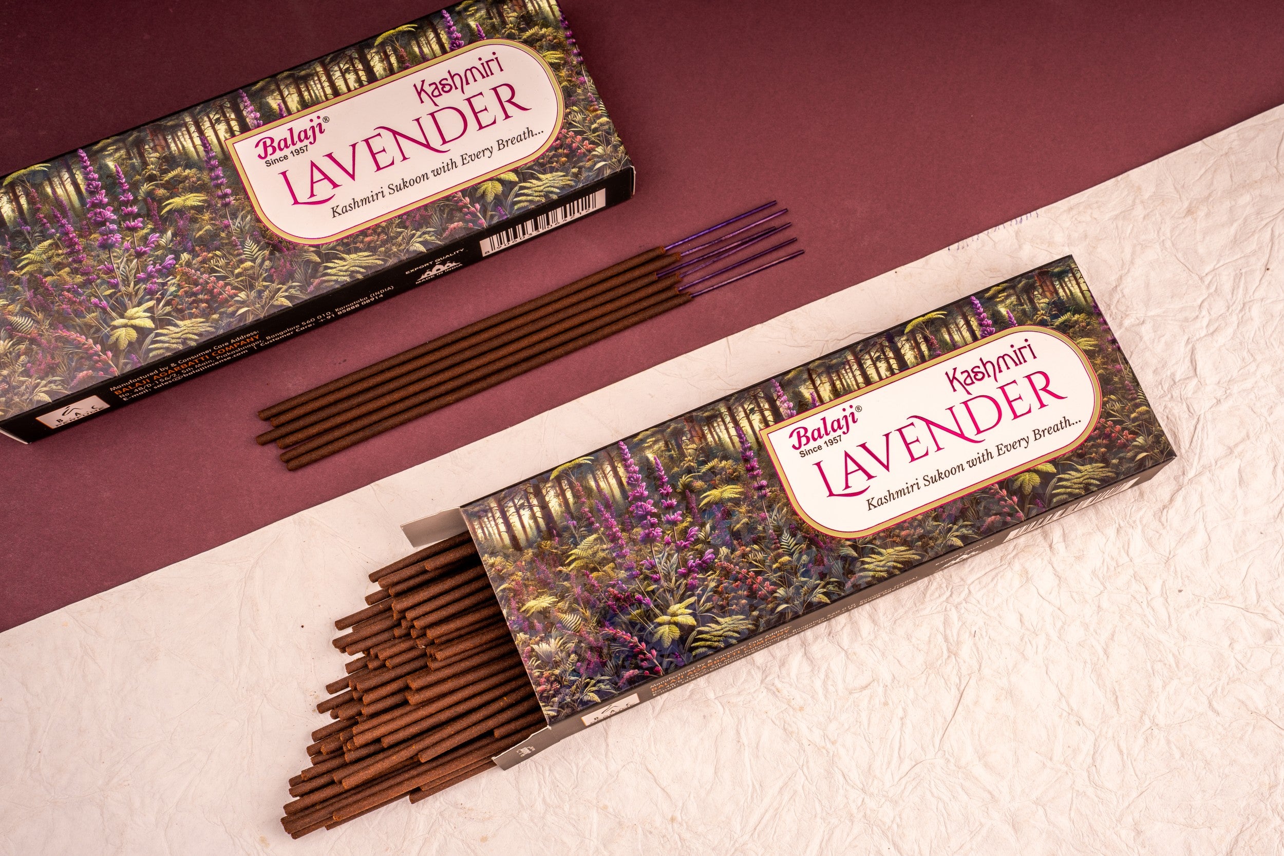 Two boxes of Balaji Lavender incense sticks on a textured surface with a maroon background