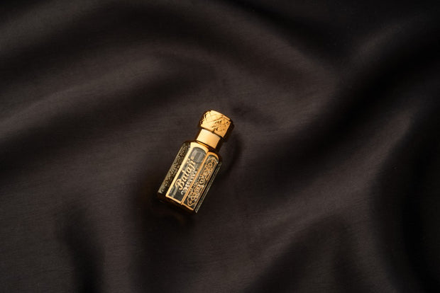 Gold perfume bottle on a dark fabric background